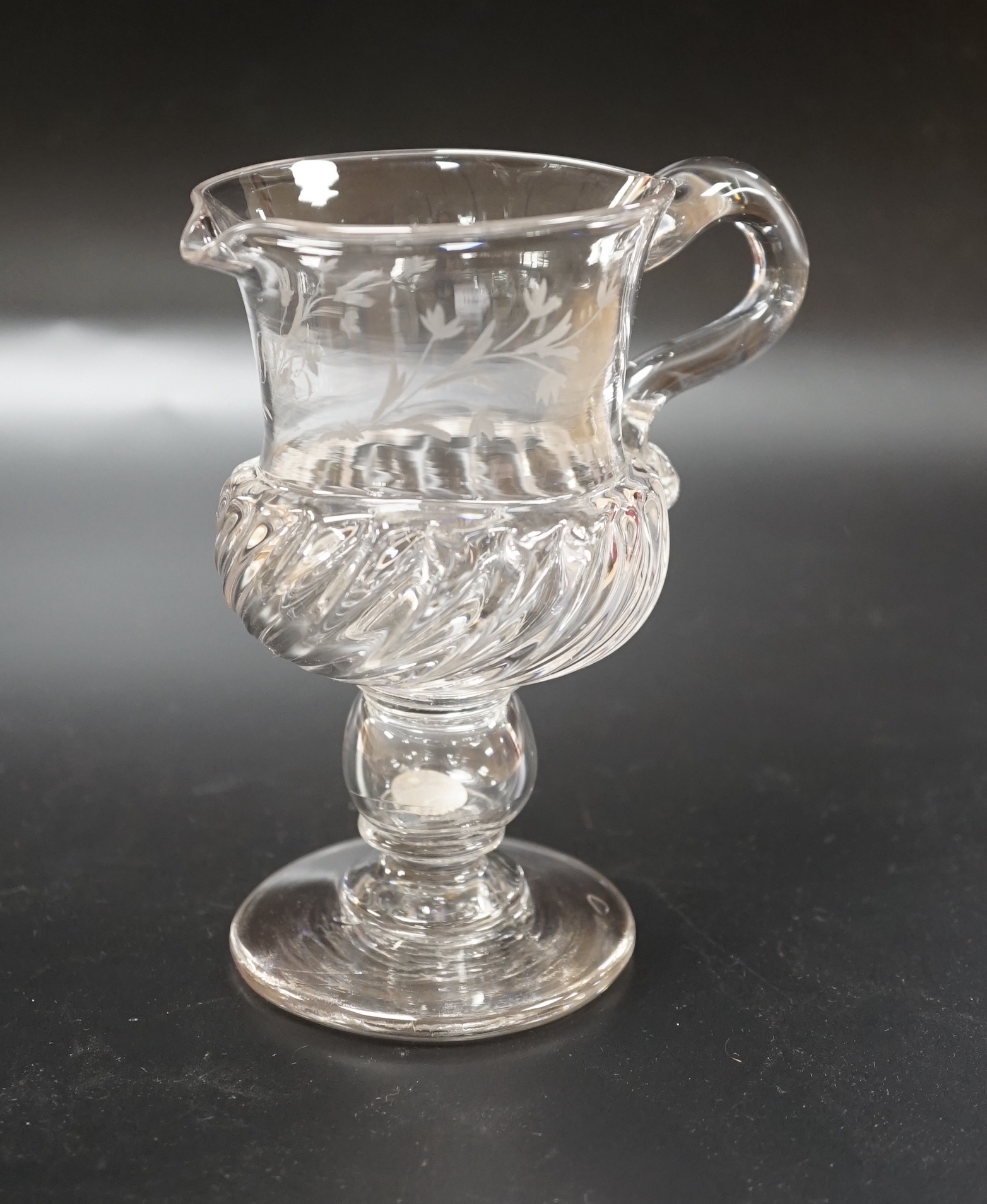 A Georgian glass jug on a stem, knop containing loose Charles II coin and engraved foliage with a central ‘SB’, 13.8cm